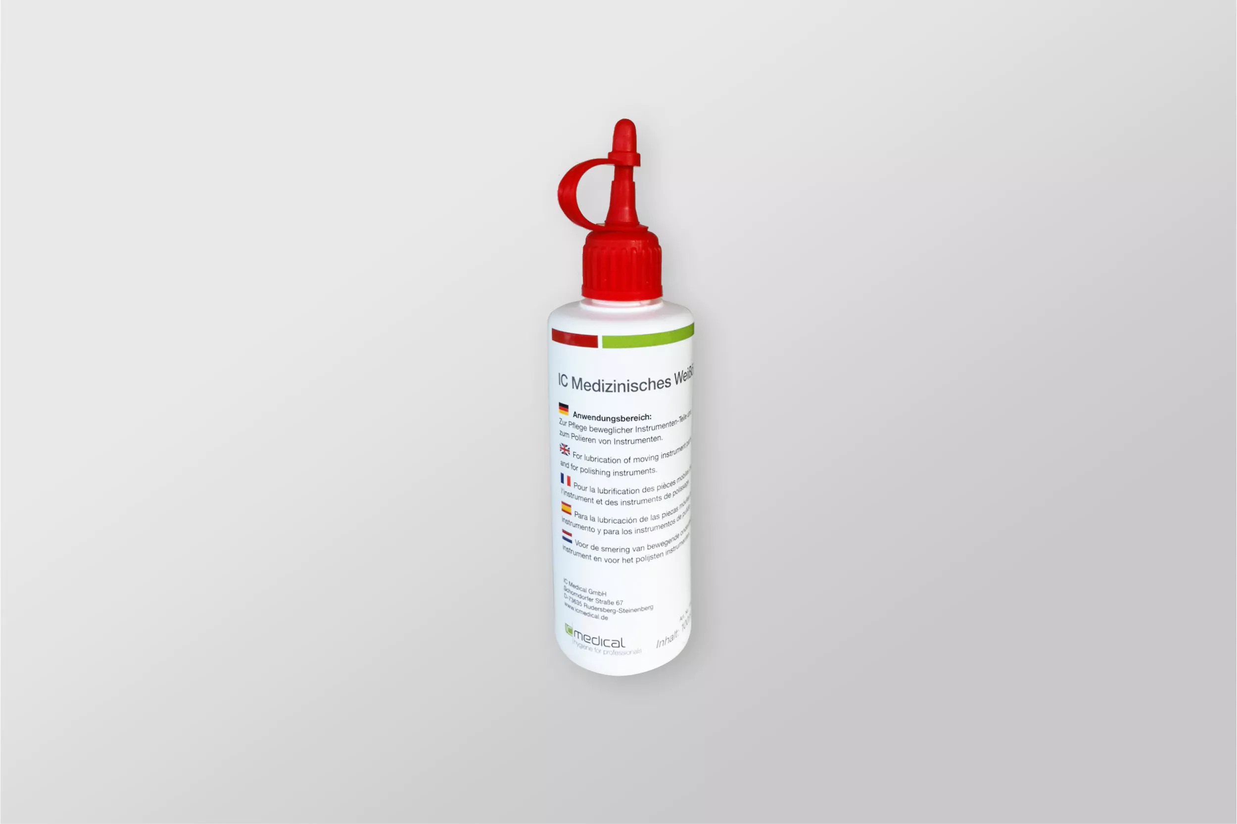 Medical lubricant bottle with a red cap and multilingual instructions for instrument lubrication, ideal for professional healthcare use.