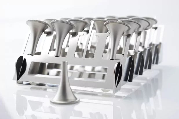 Metallhalter mit mehreren silbernen Einfülltrichtern auf reflektierendem Untergrund, ideal für Labor- oder Küchenanwendungen.
